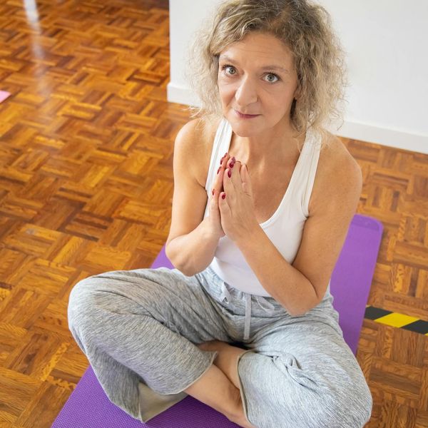 Person stretching gently indoors, showing flexibility and calm.
